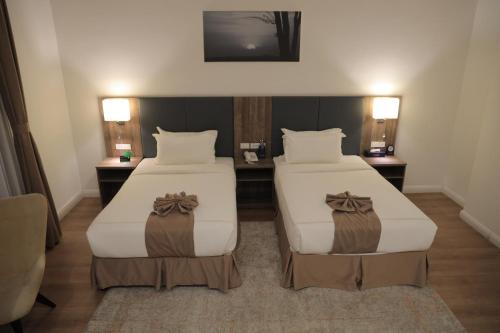 a hotel room with two beds and a television at Hotel Boutique Elmos - Meskel Flower in Addis Ababa