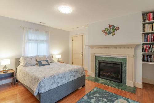 ein Schlafzimmer mit einem Bett und einem Kamin in der Unterkunft Riverfront Retreat in Urbanna with Indoor Hot Tub! in West Irvington
