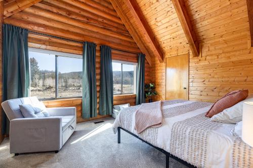 a bedroom with a bed and a chair and windows at Mtn Views and Fall Colors Panguitch 1-Acre Estate! in Panguitch