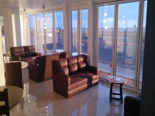 a living room with two leather chairs and a table at The Royal Windsor Hotel in Blackpool