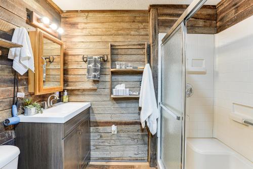 a bathroom with wooden walls and a shower and a sink at Pet-Friendly Home with River Access in Crothersville in Scottsburg