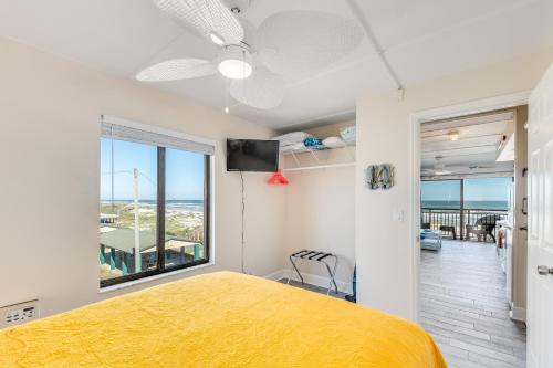 ein Schlafzimmer mit einem gelben Bett und einem Fenster in der Unterkunft Long Time No Sea! Direct OCEANFRONT Condo - End Unit Double Ocean View - Crescent Beach, Saint Augustine Florida in Crescent Beach