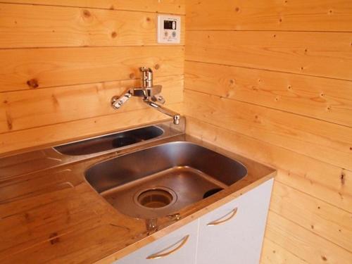 une cuisine avec un évier dans une petite maison dans l'établissement Foresters Village Kobitto Southern Alps Camp Field - Vacation STAY 78097v, à Shirasu