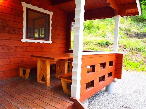 ShirasuForesters Village Kobitto Southern Alps Camp Field - Vacation STAY 78098v的小木屋的门廊,配有桌子和窗户