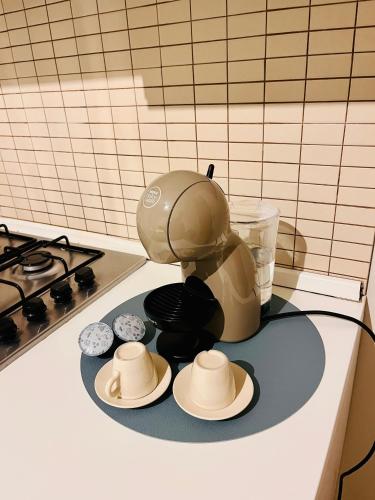 Eine Kaffeekanne steht auf einer Theke mit Hüten. in der Unterkunft House in Cave in Massafra