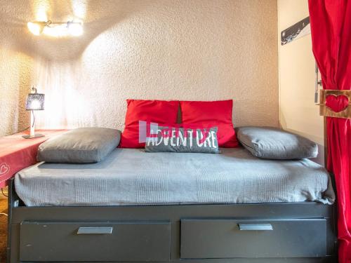 ein Schlafzimmer mit einem Bett mit einem roten Kissen darauf in der Unterkunft Charmant studio au pied des pistes, 4 pers, Corrençon-en-Vercors - FR-1-515-229 in Corrençon-en-Vercors