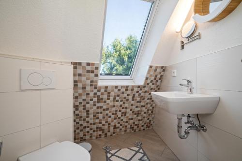 ein Badezimmer mit Waschbecken und Fenster in der Unterkunft Nordkugel - Rundes Wohnglück am Tollensesee in Wustrow
