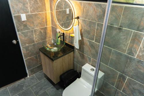 ein Badezimmer mit Toilette, Waschbecken und Spiegel in der Unterkunft Finca Moderna 2 Habitaciones con Jacuzzi Privado, Vistas Panorámica 