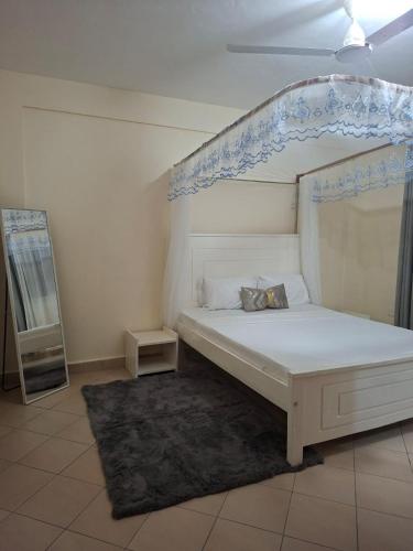 a bedroom with a white bed with an ornate canopy at Evara Luxe stay in Mombasa