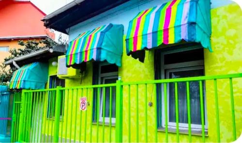 ein gelbes Haus mit einem Zaun davor in der Unterkunft Artsy fully equipped 2 bedrooms House all to yourself! in Bukarest