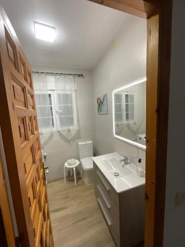 a bathroom with a sink and a toilet and a mirror at Casa rural VTAR con piscina in Rosal de la Frontera