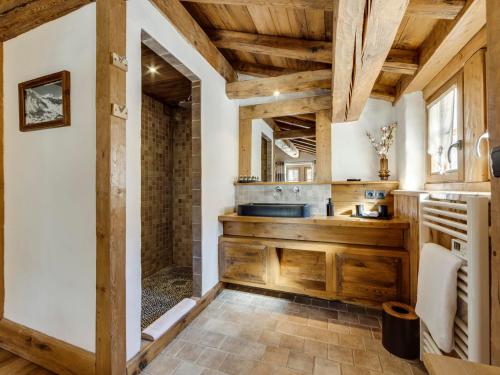 a kitchen with wooden cabinets and a sink at Chalet prestige 4 chambres, hammam, cheminée, conciergerie - FR-1-694-365 in Val dʼIsère