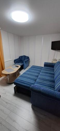 a room with a large blue bed and a table at Pas Dianą 1 aukštas in Jurbarkas