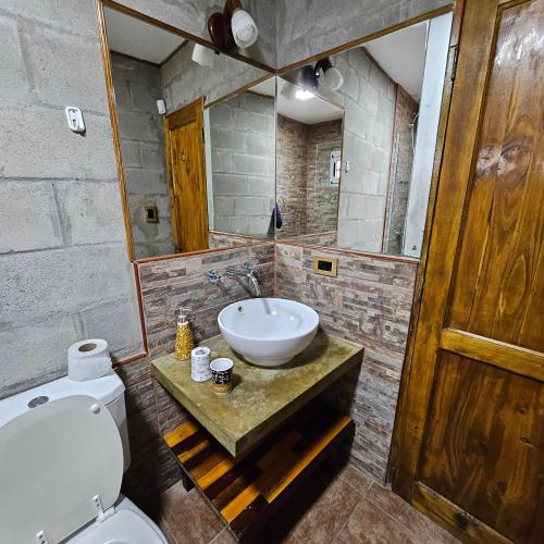 een badkamer met een wastafel, een toilet en een spiegel bij Gorriones Libres in Villa Gesell