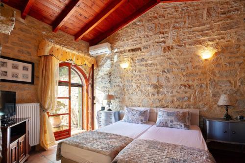 um quarto com uma cama e uma parede de pedra em Hara Villa em Agia Triada