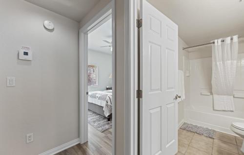 une salle de bain avec une porte menant à une chambre dans l'établissement Newly Renovated Condo, à Mesquite