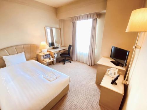une chambre d'hôtel avec un lit et un bureau avec une télévision dans l'établissement Smile Hotel Tokyo Nishikasai - Vacation STAY 97136v, à Tokyo