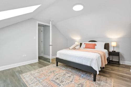 a white bedroom with a bed and a rug at 3 BD 2 BA Home near Ohare Airport sleeps 8 in River Grove