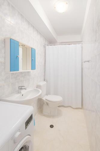 a white bathroom with a toilet and a sink at Tirana Panorama in Tirana