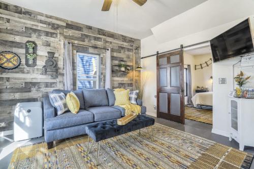 a living room with a blue couch and a tv at Station 130! Cozy Downtown Home w Fire Pit in Colorado Springs