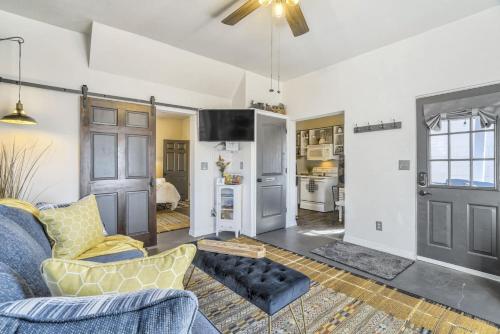 a living room with a blue couch and a ceiling fan at Station 130! Cozy Downtown Home w Fire Pit in Colorado Springs