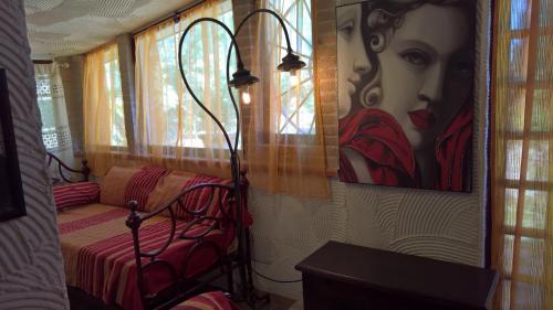 a room with a bed and a painting of a woman at Tamerici House in Montecastrilli