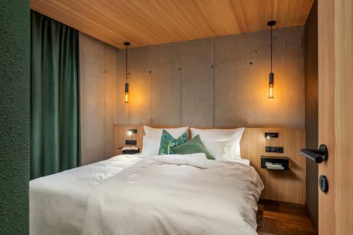 a bedroom with a large white bed with two pillows at bläkat in Ramsau im Zillertal