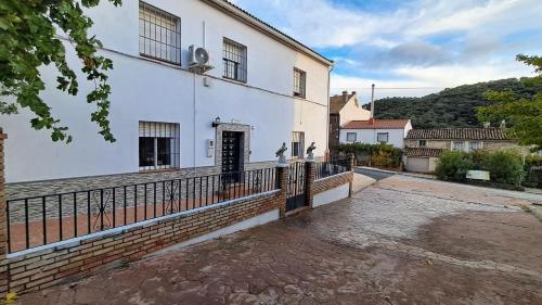 un edificio blanco con una puerta y una valla en Villamaría, Alma de Despeñaperros, en Miranda del Rey