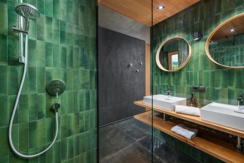 a bathroom with a shower and a sink and mirror at bläkat in Ramsau im Zillertal