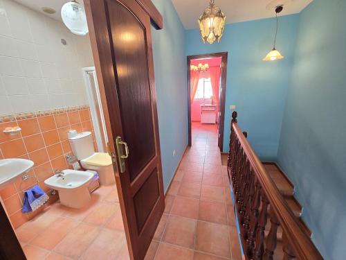 ein Badezimmer mit Toilette und Waschbecken und einer Tür in der Unterkunft VV Zumacal La Palma in San Antonio