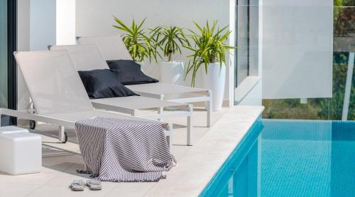 ein weißer Sessel neben einem Pool in der Unterkunft Ferienhaus mit Privatpool für 8 Personen ca 200 m in Veliko Brdo, Dalmatien Biokovo-Gebirge in Veliko Brdo