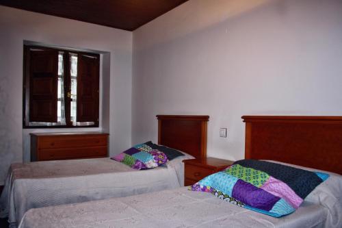 um quarto com 2 camas e uma janela em Apartamentos El Cuetu em Llanes