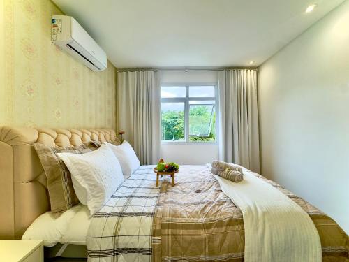 a bedroom with a bed and a window at Apto a 10 min da Vila Germânica, dois quartos, salas de estar e jantar, cozinha completa, sacada com churrasqueira, Wi-Fi, Piscina, academia, mercadinho 24 horas e Vaga de garagem in Blumenau