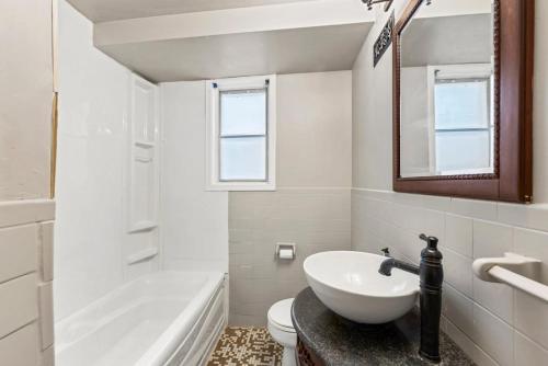 a bathroom with a sink and a toilet and a mirror at 4 Bedroom full house with 4 car parking in Kingston