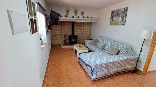 Una sala de estar con un sofá y un televisor. en Villamaría, Alma de Despeñaperros, en Miranda del Rey