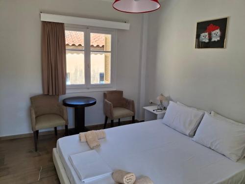 um quarto com uma cama, 2 cadeiras e uma janela em Nafpaktos happy town studio in port em Lepanto
