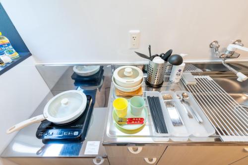 a kitchen counter with dishes and utensils on a shelf at Setsuki no Yado - Vacation STAY 20324 in Kamagaya