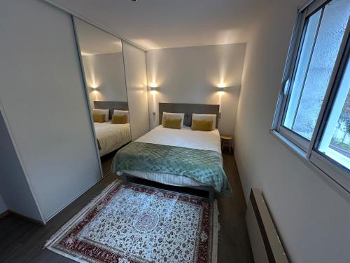 une petite chambre avec un lit et un miroir dans l'établissement Une appartement entier à Brive la gaillarde, à Brive-la-Gaillarde