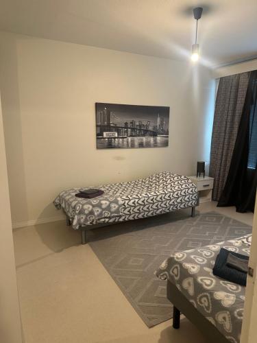 a bedroom with two beds and a painting on the wall at Hostel400Kokkola Kaksio Hollihaka in Kokkola