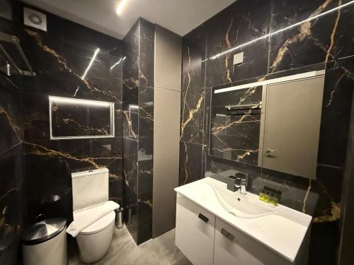 Un baño con lavabo blanco y inodoro. en Onar Exclusive Studio Suite, en Oroklini