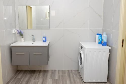 een badkamer met wastafel en wasmachine bij לב בית שאן in Bet Sheʼan