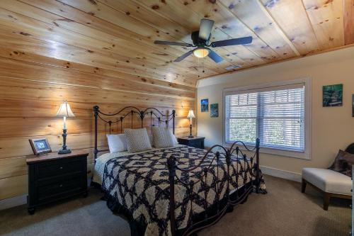 una camera da letto con un letto con soffitto in legno di Stoney Brook Cottage at Echota a Boone