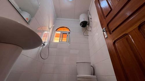a small bathroom with a shower and a window at BARAN Home in Yaoundé