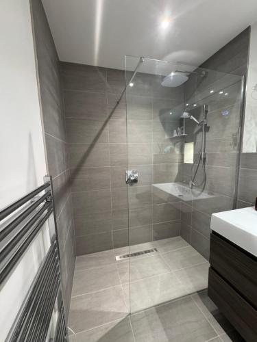 a shower with a glass door in a bathroom at Turnpike House in Glanton