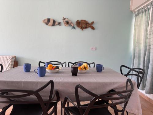 a table with blue cups and bowls of fruit on it at Las Grutas Star in Las Grutas