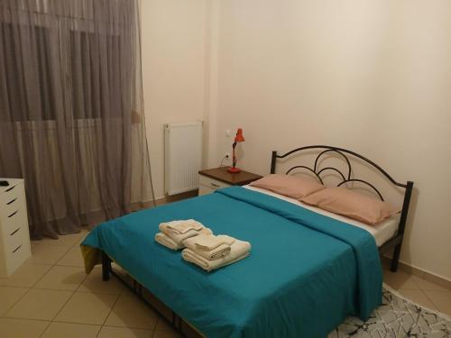 a bedroom with a blue bed with towels on it at sofi in Komotini