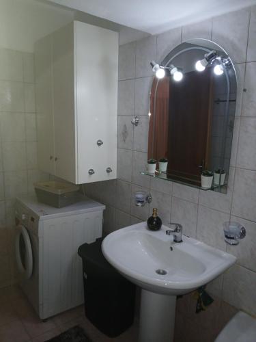 a bathroom with a sink and a mirror and a toilet at sofi in Komotini