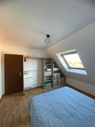 a attic bedroom with a bed and a skylight at Appartement Dôme 2 suites parentales in Ostwald