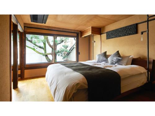 une chambre avec un grand lit avec une grande fenêtre dans l'établissement Kishoan did - Vacation STAY 81774v, à Shimmachidōri