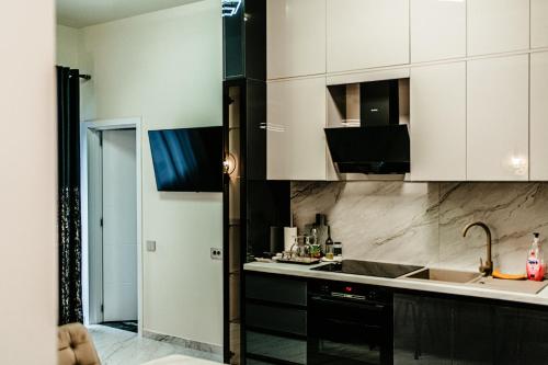 a kitchen with black and white cabinets and a sink at Jessica luxury Apartament in Curtea de Argeş